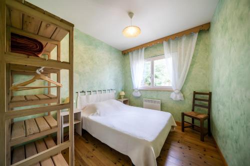 a bedroom with a bunk bed and a ladder at Gîte Des Houx in Le Soulié