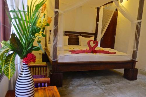 a bedroom with a bed with a heart on it at Villa Boreh Beach Resort and Spa in Tejakula