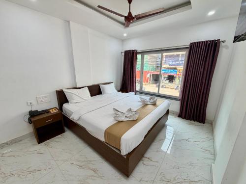 a bedroom with a large bed and a window at Hotel Sai in Udupi