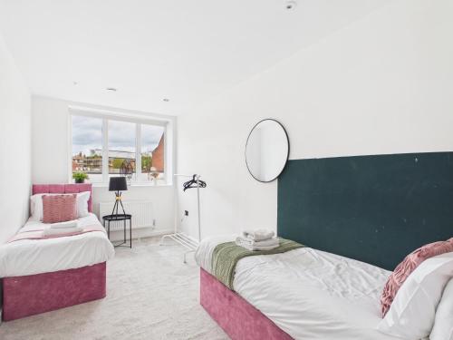 a bedroom with two beds and a mirror on the wall at Luxury Two Bed | Sleeps 6 | 5 beds in Brent Station