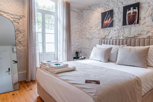 a bedroom with a bed with two towels on it at Celtic Lodge - Guest House in Viseu