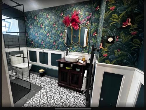 a bathroom with a sink and a floral wallpaper at Nana Mac Chambre D'hôtes in Limalonges