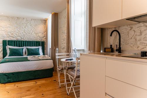 a small bedroom with a bed and a kitchen at Celtic Lodge - Guest House in Viseu