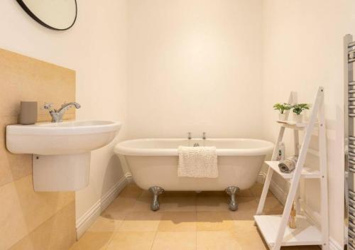 a bathroom with a sink and a bath tub and a toilet at Spacious 3 bed, Parking, Long stays welcome, Relocators, Families, Contractors in Knaresborough
