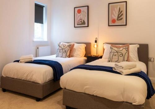a bedroom with two beds and a table with a lamp at Spacious 3 bed, Parking, Long stays welcome, Relocators, Families, Contractors in Knaresborough