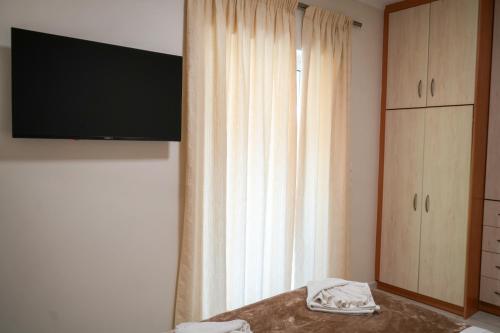 a bedroom with a bed with a television and a window at Candia Relax House in Kandia
