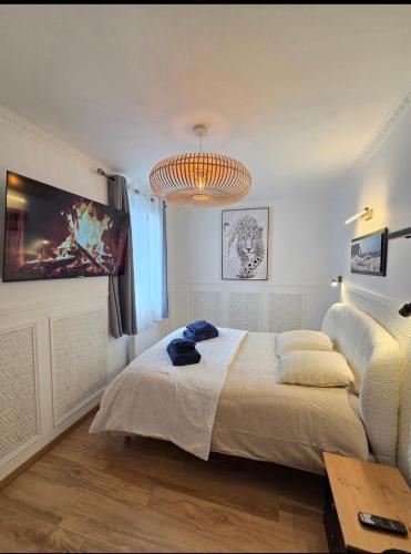 a bedroom with a large bed and a chandelier at White House in Étretat