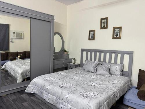 a bedroom with a large bed and a mirror at ANA Apartment in Hail