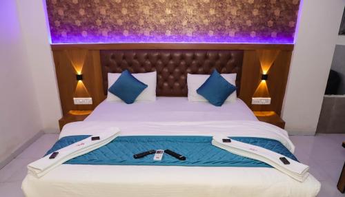 a bedroom with a large bed with blue and purple lighting at Ruby Lodging And Boarding in Mangrul