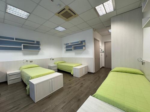 two beds in a room with green beds at Campus Circuito 71 - Casa per Ferie in Pescara