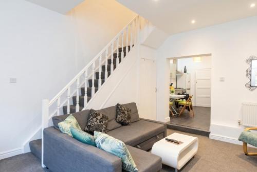 a living room with a couch and a staircase at Character Cottage with Private Parking in Central Leeds, Near LGI in Leeds