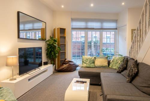 a living room with a couch and a flat screen tv at Character Cottage with Private Parking in Central Leeds, Near LGI in Leeds
