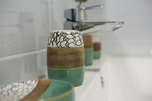 a cup sitting on a counter next to a sink at Apartman Nora Herceg Novi in Zelenika