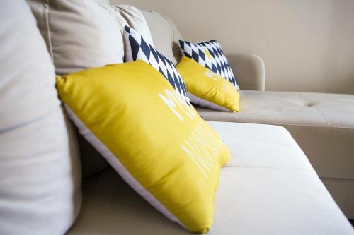a white couch with yellow pillows on it at Apartman Nora Herceg Novi in Zelenika