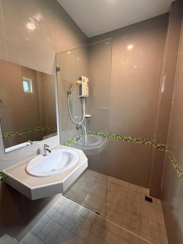 a bathroom with a sink and a shower at Khaolak Beachhouse Kelolo in Khao Lak
