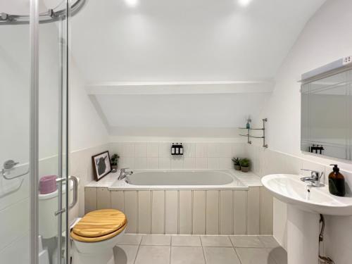 a bathroom with a tub and a toilet and a sink at The Stables Lydeard St Lawrence in Combe Florey
