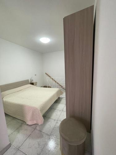 a small bedroom with a bed and a stool at Il Vicoletto in Biccari