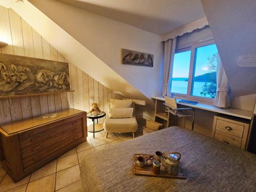 a room with a bed and a desk and a window at L'Escale au Lac - Vue panoramique - parking & plage privés in Duingt