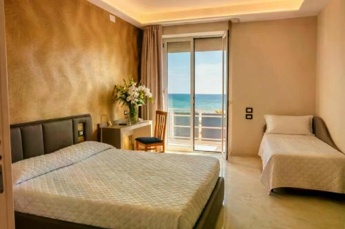 a bedroom with two beds and a view of the ocean at Hotel Kursaal in Rimini