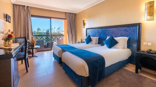 a hotel room with two beds and a balcony at Zalagh Kasbah Hotel & Spa in Marrakesh