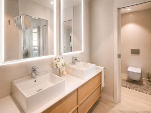 a bathroom with two sinks and a mirror and a toilet at RenTenerife Elim Ocean in La Tejita