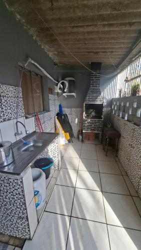 a kitchen with a sink and a counter top at Casa 2 minutos a pé da Praia de INDAIÁ in Bertioga