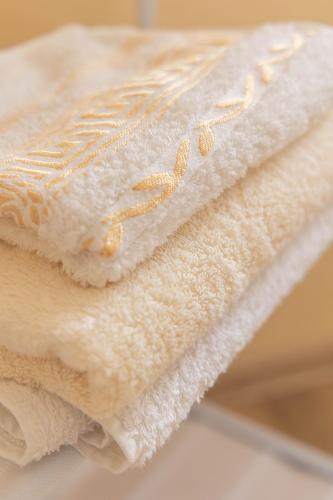 a pile of white towels with gold pins on them at Strawberry in Borjomi