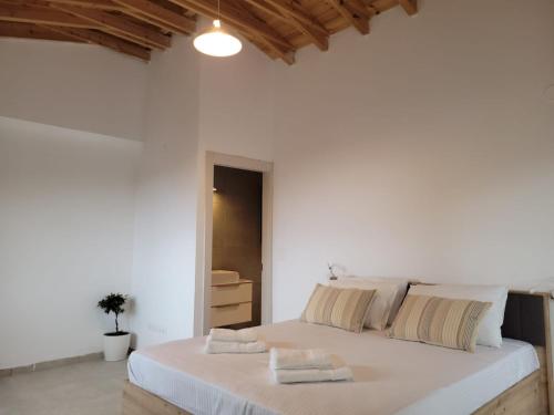 a white bedroom with a large bed with white walls at Forest and Sea view villas in Samothraki