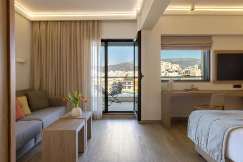 a hotel room with a bed and a couch at Golden Age Athens Hotel in Athens