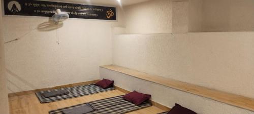a room with a ceiling fan and mats on the floor at Himalayan siddh yog ashram in Rishīkesh