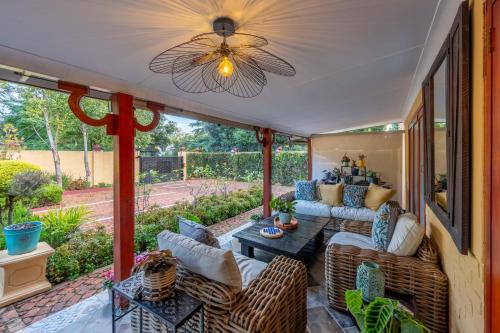 a screened in porch with couches and a table at Hampton House Guest House in Centurion