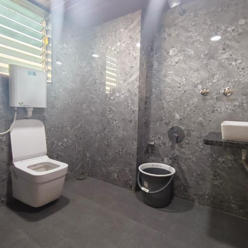 a bathroom with a toilet and a sink at Sai Srushti Residency in Kalyan