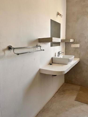 a bathroom with a sink and a mirror on the wall at Hide Away Villa in Watamu