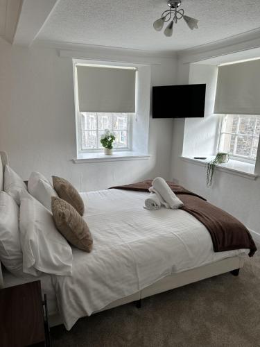 a bedroom with a bed with pillows and a television at Towerknowe in Hawick
