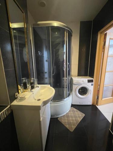 a bathroom with a shower and a sink and a washing machine at Тownhouse99 in Petropavlovskaya Borshchagovka