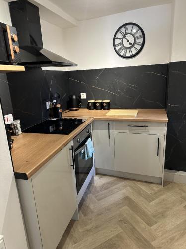 a kitchen with a counter and a clock on the wall at Towerknowe in Hawick
