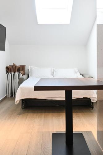 a white bedroom with a bed and a table at Šangulin Palace M in Biograd na Moru