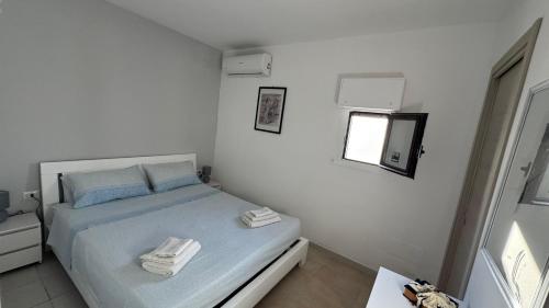 a small bedroom with a bed with towels on it at Villa Hermosa Beach in Margherita di Savoia