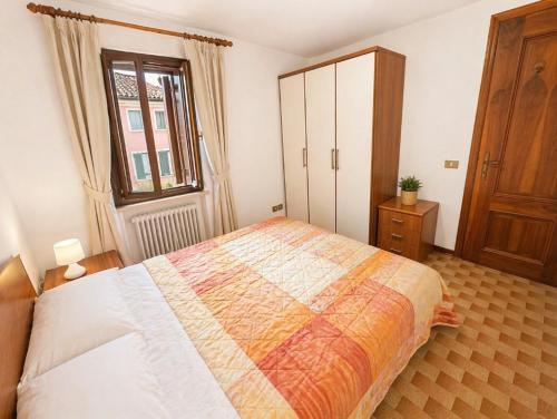 a bedroom with a bed and a cabinet and a window at La Casa del Mare in Caorle