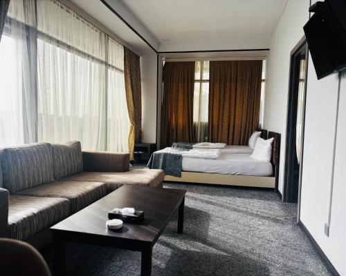 a living room with a couch and a bed at Crossway Hotel Baku in Baku
