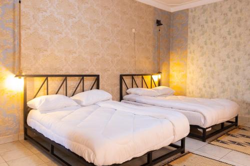 two beds sitting next to each other in a room at UmuTea Villa - Authentic East African local experience in Kigali