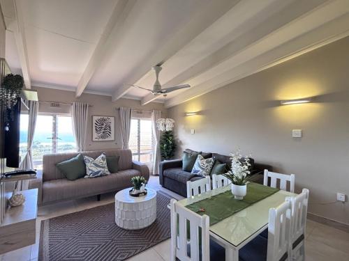 a living room with a couch and a table at Chakas Rock Ocean View Bliss Ballito in Ballito