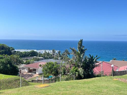 a house on a hill next to the ocean at Chakas Rock Ocean View Bliss Ballito in Ballito
