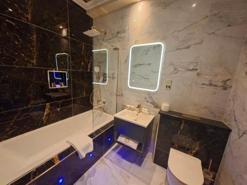 a bathroom with a sink and a tub and a toilet at Kinnitty Castle Hotel in Kinnitty