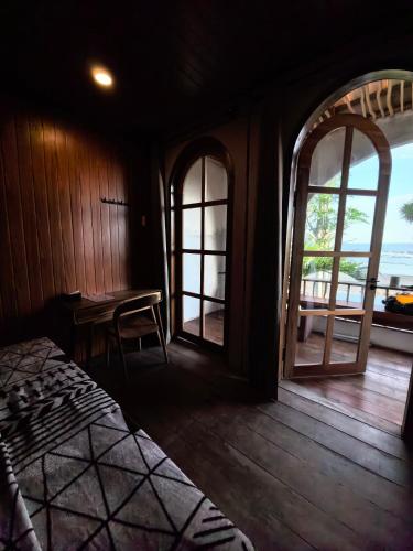 a bedroom with a bed and two windows and a table at The Beachbreaks Medewi in Airsatang
