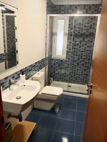 a bathroom with a toilet and a sink and a shower at Apartamento Jurásico in Barreiros