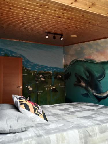 a bedroom with a whale painting on the wall at Apartamento Jurásico in Barreiros