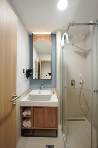 a bathroom with a sink and a shower at Hotel Botika in Kraljevo