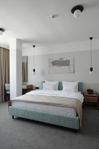 a bedroom with a large bed with white sheets at Hotel Botika in Kraljevo