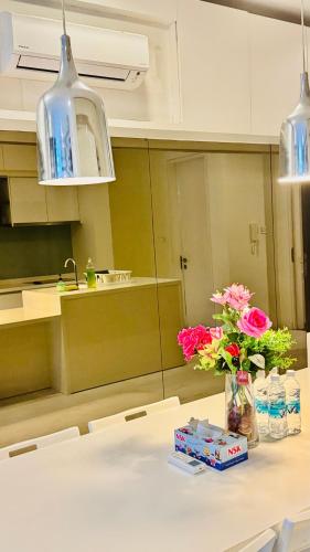 a kitchen with a table with flowers in a vase at Platinum Astern SUITES by KLCC in Kuala Lumpur